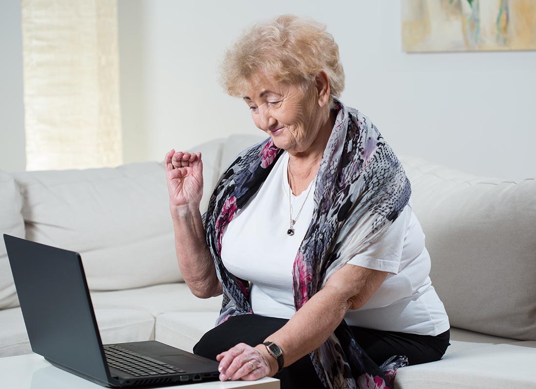 A lady using her laptop to Skype with the family