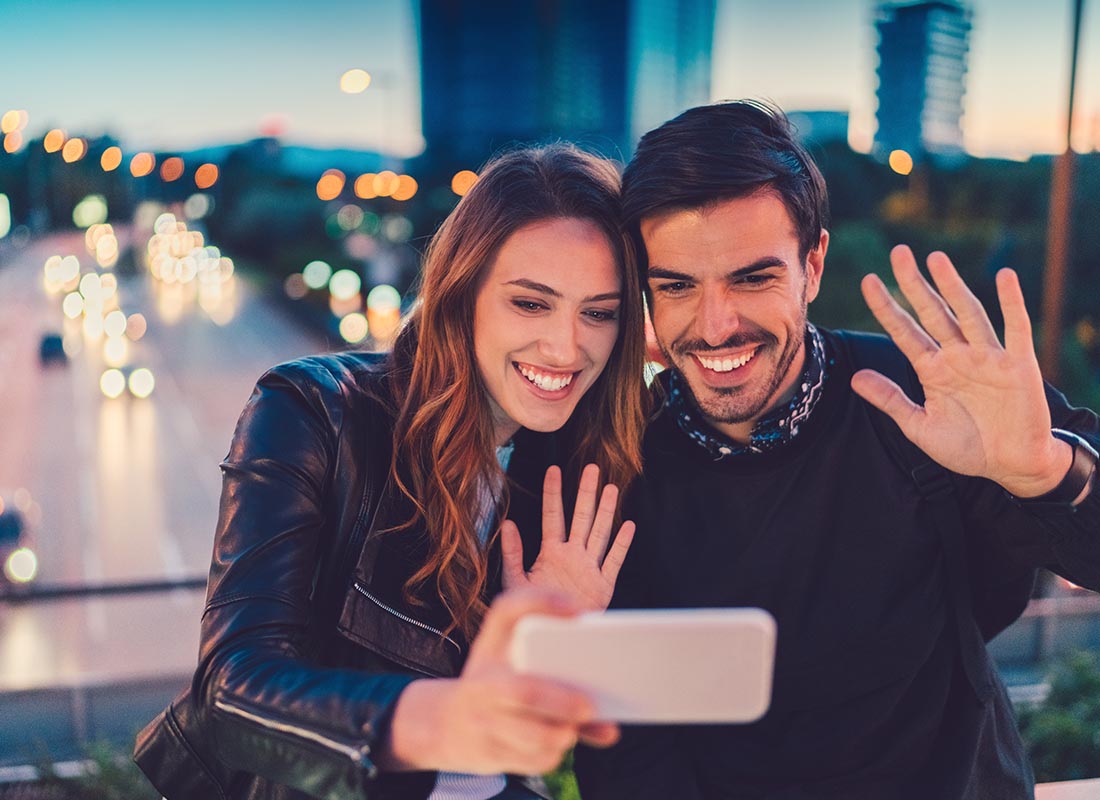 A couple greeting their family back home over a video chat