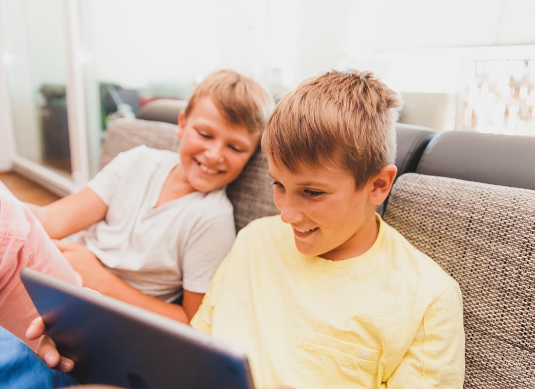 Two boys happily using FaceTime to chat to their cousins