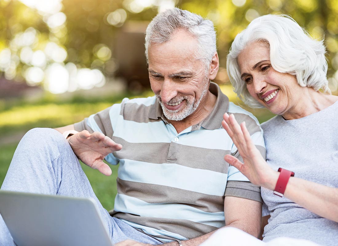 A couple waving to their children using Facetime on their laptop