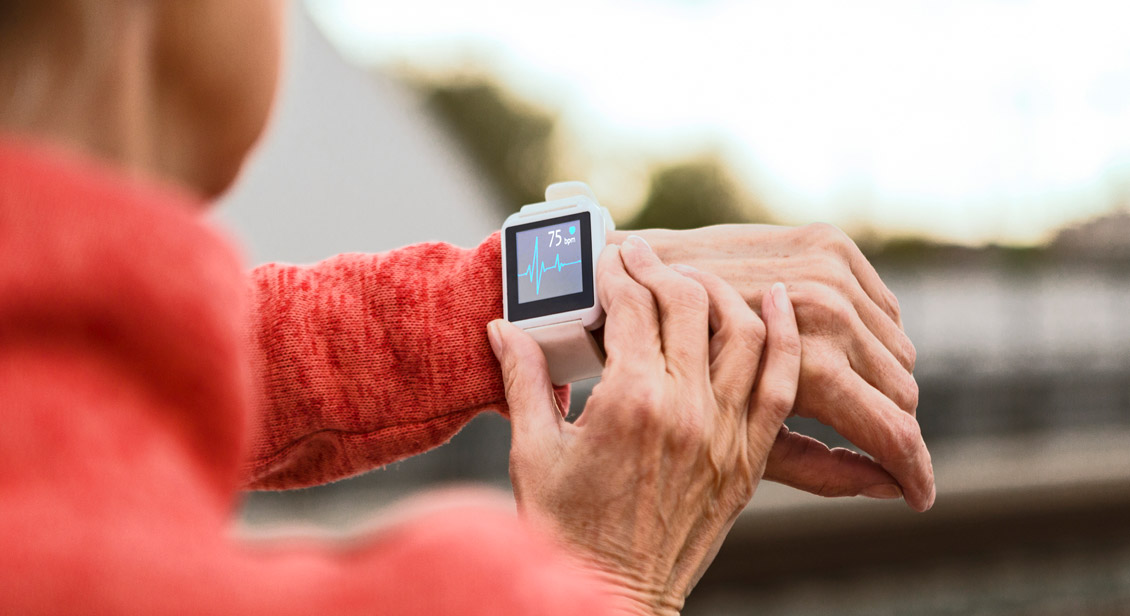 Senior woman checks her heart rate on smart watch.