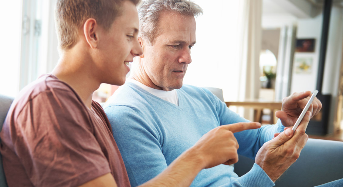 Son helping Father with mobile phone