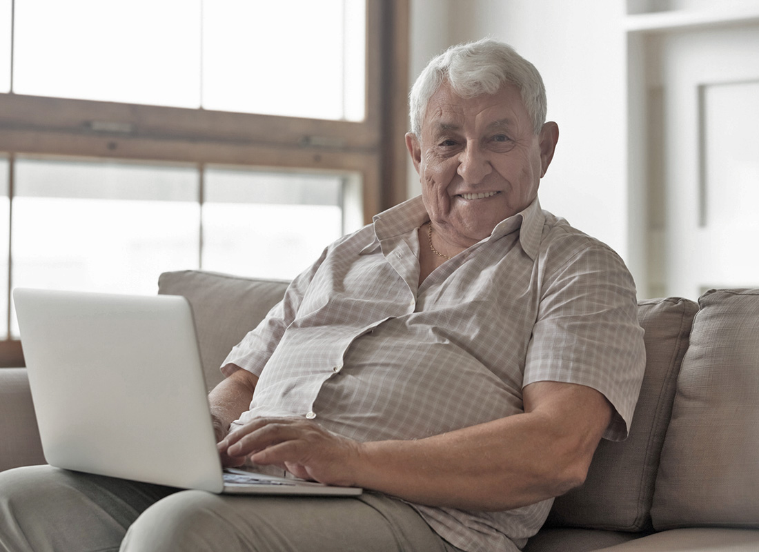 A gentleman sitting comfortably with a laptop ready to check his online bank account