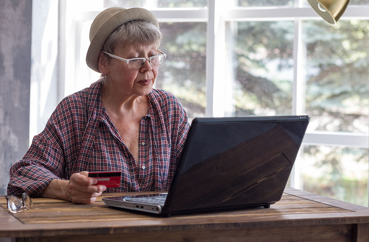 older lady at desk using laptop