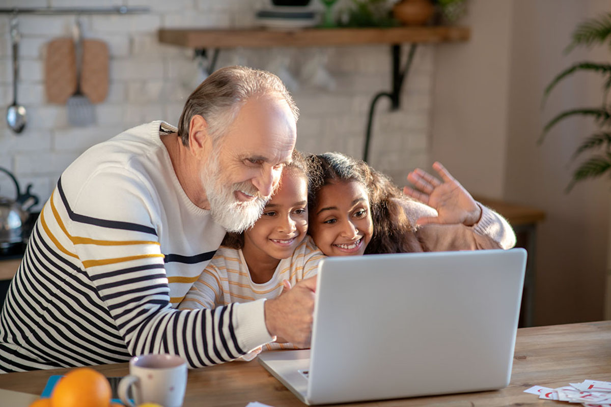 man using laptop with his grand children