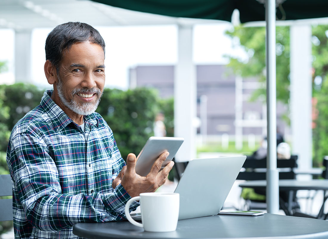 A gentleman stays in touch with loved ones via social media on his laptop and tablet.