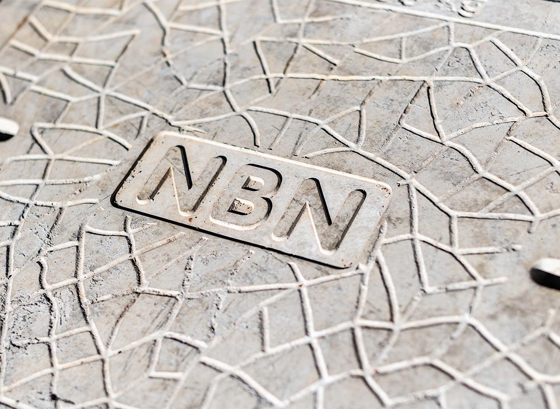 A rectangular, concrete manhole cover for an nbn cable pit with the letters 'NBN' embossed.