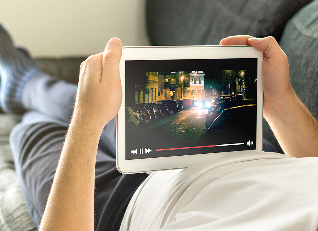 Someone relaxing while watching a movie on their tablet