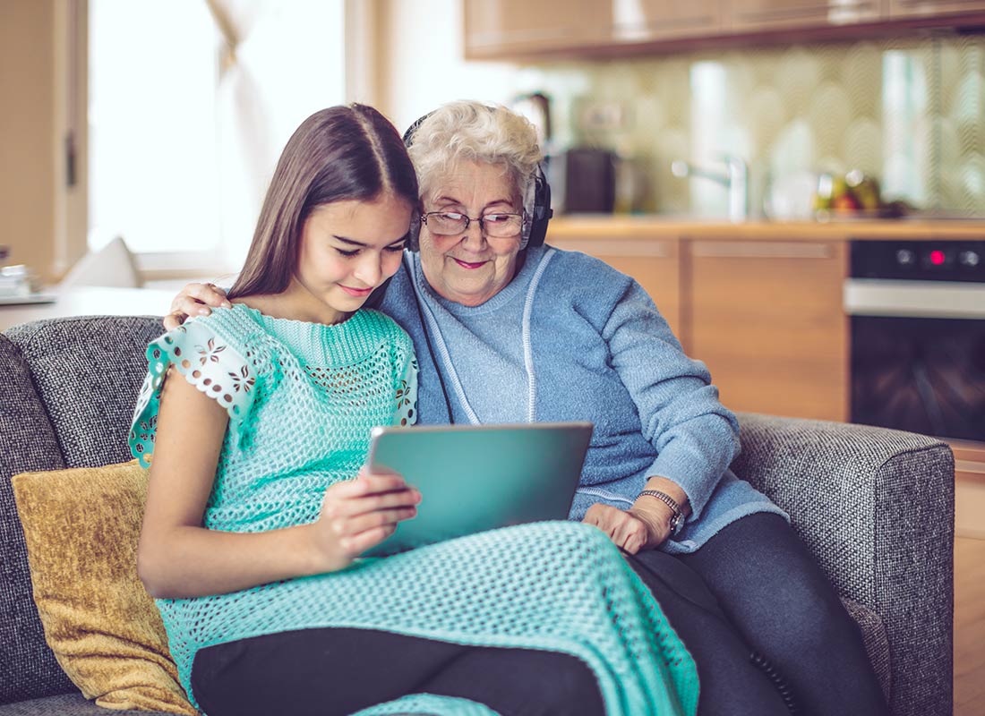 A granddaughter and grandmother enjoying time together with their tablet