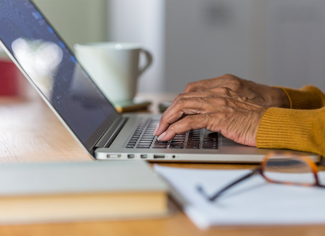 Someone typing an email on their laptop