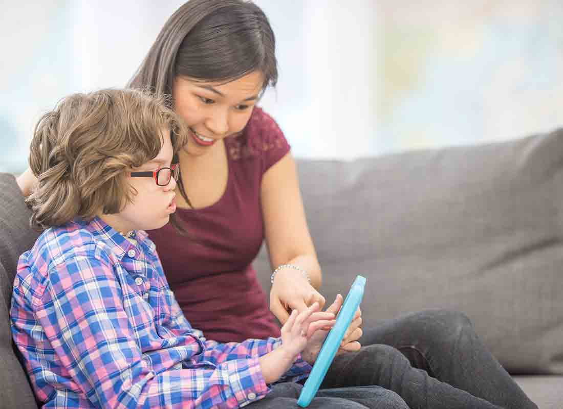 A mother and son using a smart device together