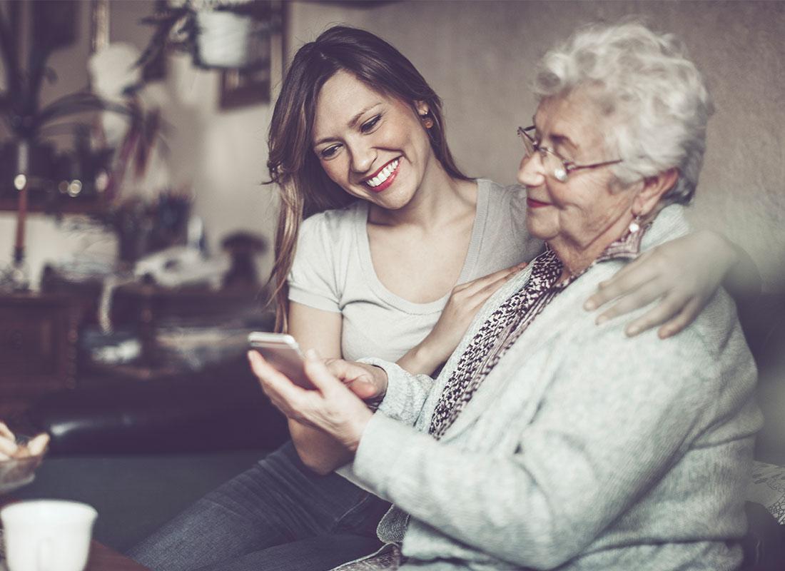 Mum and daughter sharing photos on a smartphone