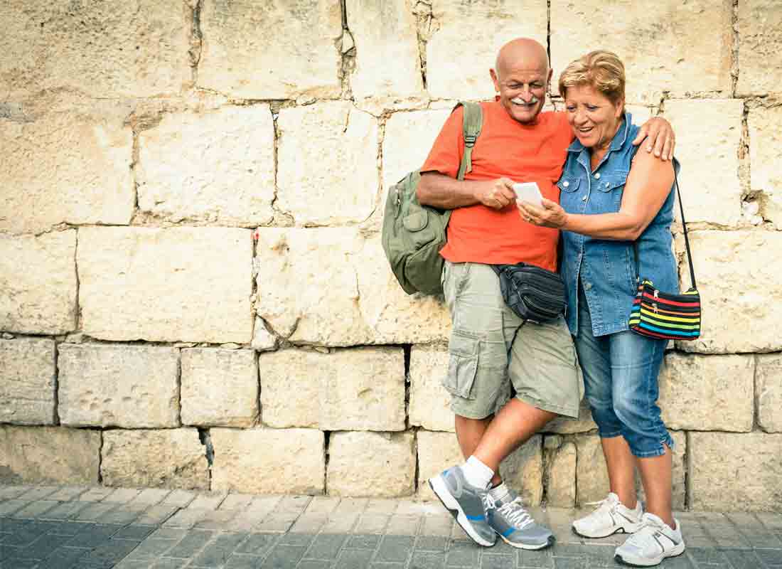 A couple on holiday stop to check their location using their mobile phone