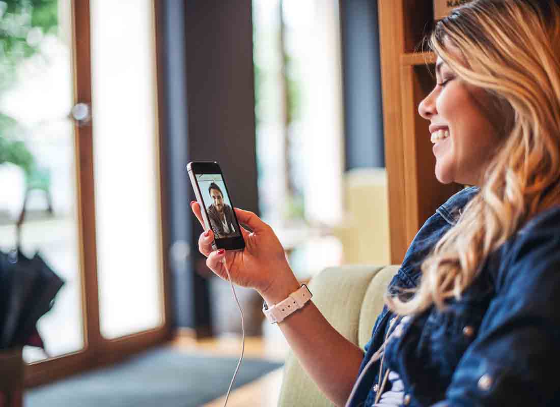 A sister and brother chatting to each other using a video calling app on their mobile phones