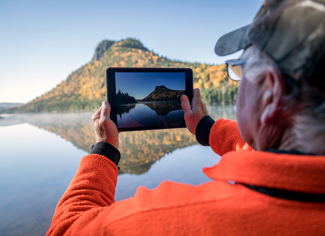 A tourist taking a photo of a local view with his tablet device