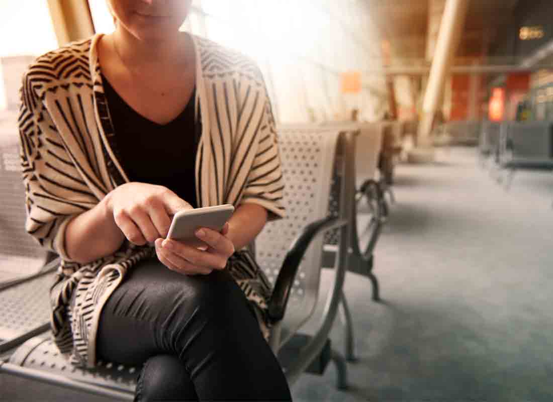 A passenger switching their mobile phone to Flight Mode whilst in the airport terminal