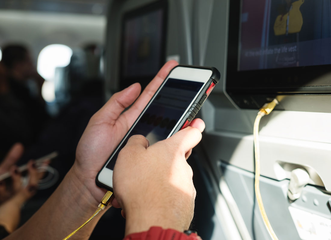 A passenger listening to music on their mobile phone during a flight