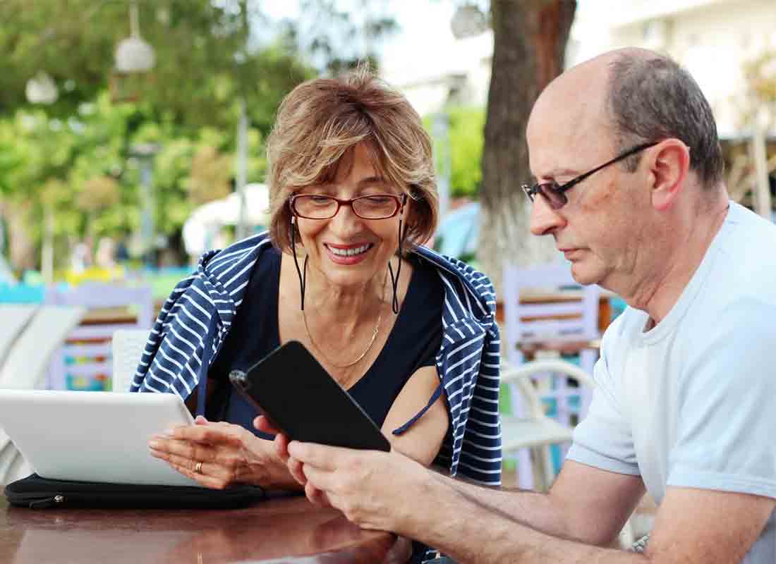 A couple use their tablet at an al fresco café