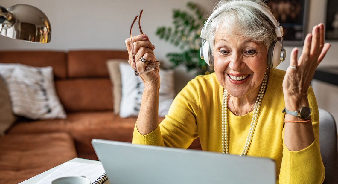 Happy senior woman looking at laptop and talking on a video call.