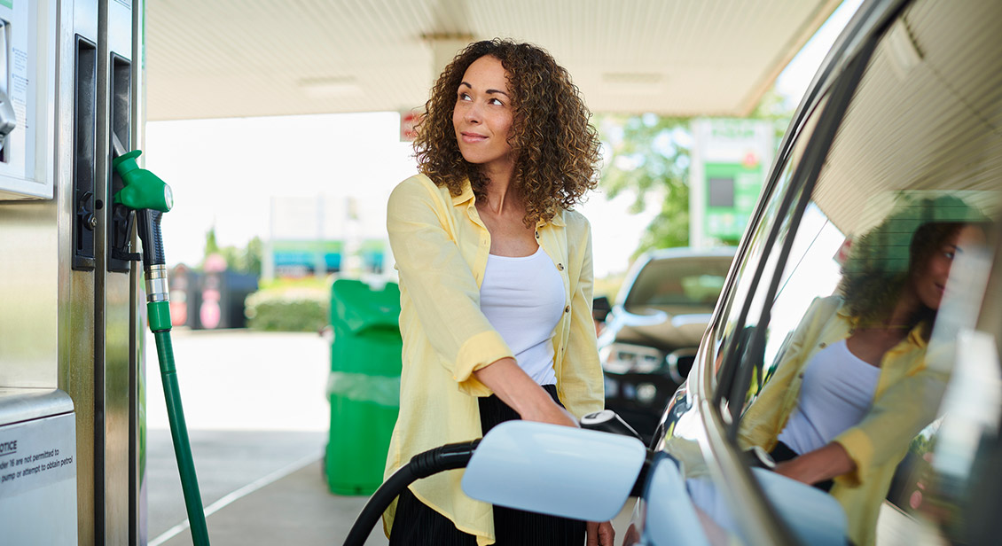 Light brown skin woman filling up petrol at the peetrol bowser 