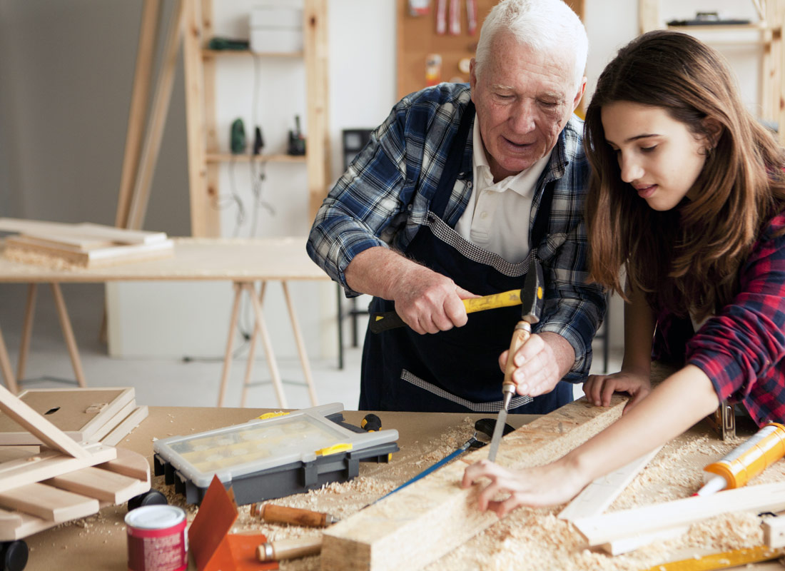 A grandfather explains how to use carpentry tools to his granddaughter